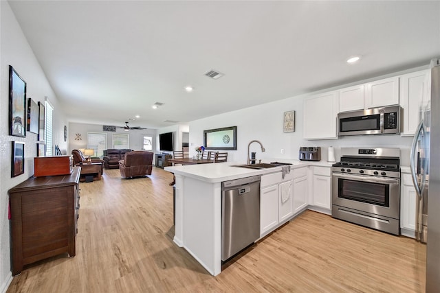 5003 Stratton Ln, Rosharon, TX 77583 - kitchen featuring stainless steel appliances, a sink, a peninsula, white cabinetry, and recessed lighting