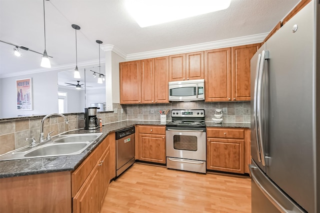 1711 Old Spanish Trl Unit 330, Houston, TX 77054 - kitchen featuring appliances with stainless steel finishes, a sink, crown molding, and brown cabinetry