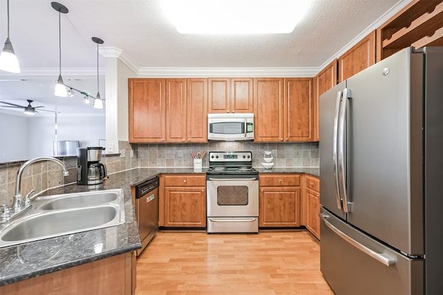 1711 Old Spanish Trl Unit 330, Houston, TX 77054 - kitchen featuring appliances with stainless steel finishes, a sink, brown cabinetry, ceiling fan, and tasteful backsplash