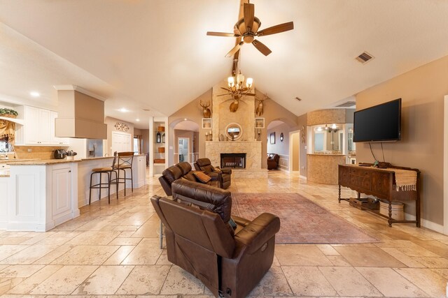 632 Western Acres Dr, El Campo, TX 77437 - living area with a ceiling fan, arched walkways, stone tile floors, a chandelier, and a tiled fireplace