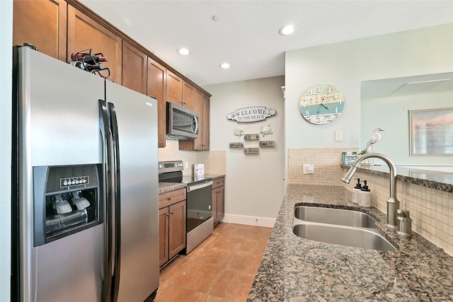 27020 Estuary Dr Unit 302, Galveston, TX 77554 - kitchen with stainless steel appliances, a sink, brown cabinets, tasteful backsplash, and recessed lighting