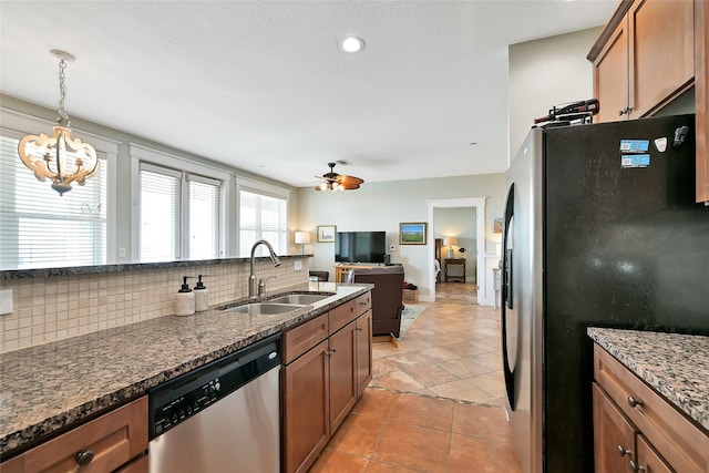 27020 Estuary Dr Unit 302, Galveston, TX 77554 - kitchen with stainless steel appliances, a sink, brown cabinetry, and backsplash
