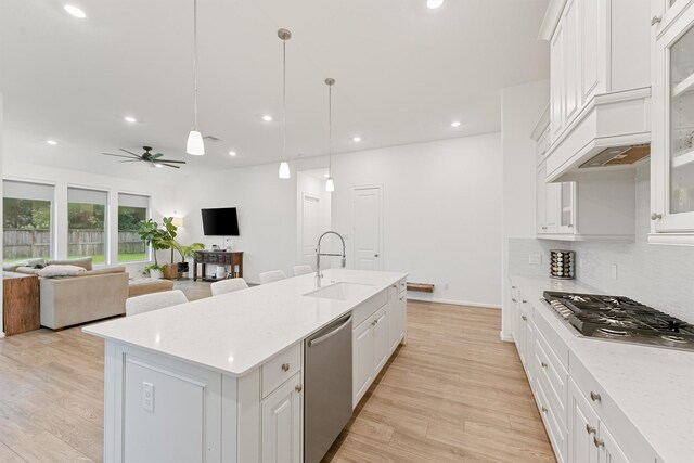 5160 Andorra Bend Ln, Porter, TX 77365 - kitchen featuring stainless steel appliances, a sink, light wood-style floors, white cabinets, and recessed lighting