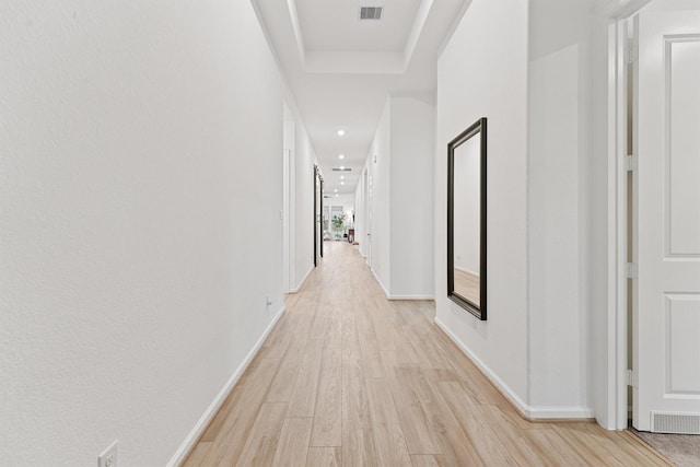 5160 Andorra Bend Ln, Porter, TX 77365 - hallway featuring light wood-style flooring, baseboards, recessed lighting, and a tray ceiling