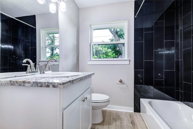 5858 Beldart St, Houston, TX 77033 - bathroom with vanity, toilet, plenty of natural light, and wood finished floors