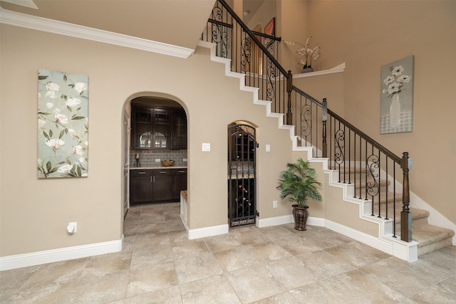 27619 Dalton Bluff Ct, Katy, TX 77494 - entryway featuring crown molding, stairway, arched walkways, and baseboards