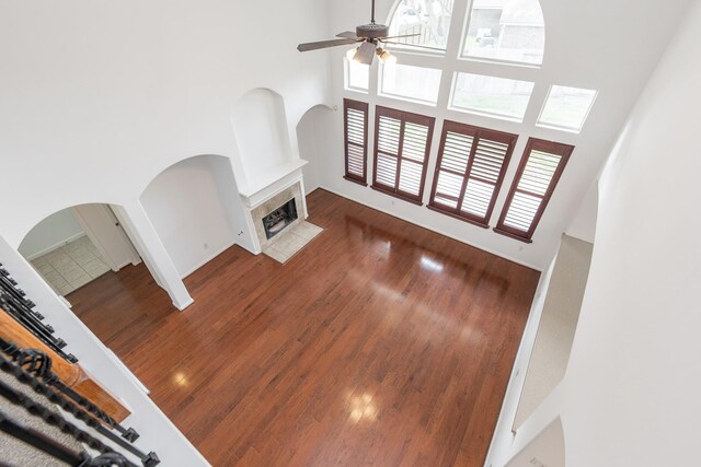 3604 Dogwood Blossom Ct, Pearland, TX 77581 - unfurnished living room featuring a high ceiling, ceiling fan, arched walkways, plenty of natural light, and wood finished floors