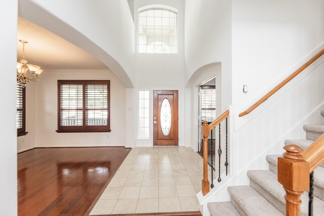 3604 Dogwood Blossom Ct, Pearland, TX 77581 - entrance foyer with arched walkways, stairway, a chandelier, wood finished floors, and a towering ceiling