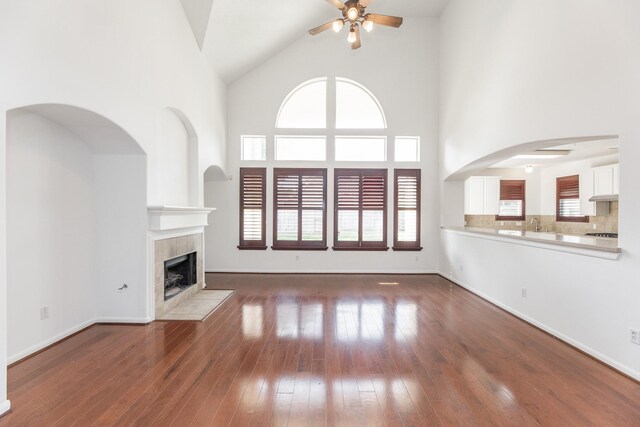 3604 Dogwood Blossom Ct, Pearland, TX 77581 - unfurnished living room with ceiling fan, a high ceiling, a tile fireplace, and plenty of natural light