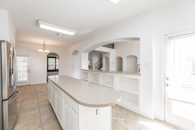 3604 Dogwood Blossom Ct, Pearland, TX 77581 - kitchen featuring stainless steel fridge with ice dispenser, light tile patterned floors, a center island, white cabinetry, and light countertops