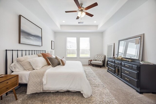 8018 Royal Palm Dr, Fulshear, TX 77441 - bedroom featuring multiple windows, light colored carpet, a tray ceiling, ceiling fan, and recessed lighting