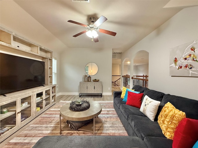 210 Black Swan Pl, The Woodlands, TX 77354 - living area featuring arched walkways, ceiling fan, wood finished floors, lofted ceiling, and baseboards