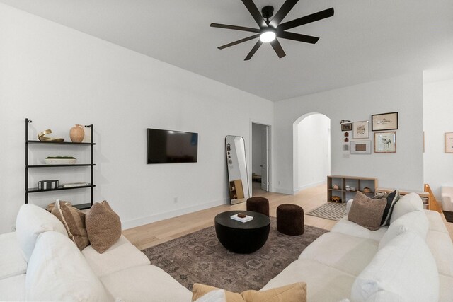 17460 Chestnut Cove Dr, Conroe, TX 77302 - living room with arched walkways, a ceiling fan, light wood-type flooring, baseboards, and vaulted ceiling