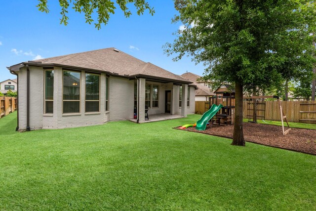17460 Chestnut Cove Dr, Conroe, TX 77302 - rear view of house featuring a playground, roof with shingles, brick siding, and a patio
