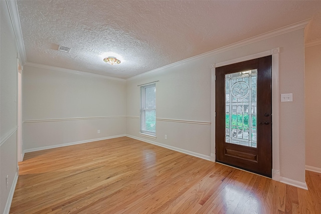 2718 Silver Falls Dr, Kingwood, TX 77339 - foyer entrance featuring plenty of natural light, light wood-type flooring, ornamental molding, and a textured ceiling