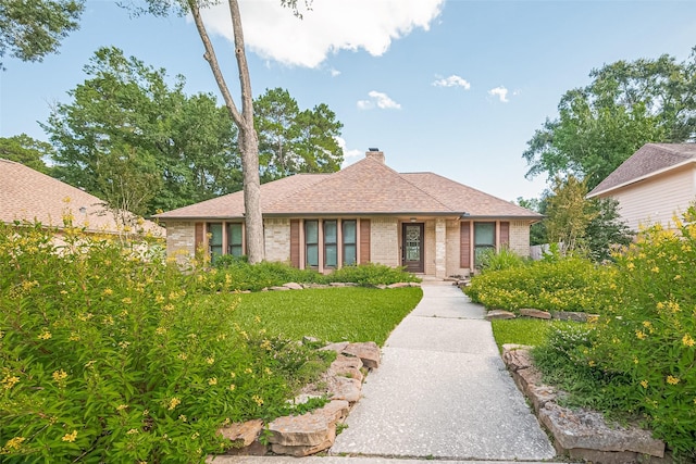 2718 Silver Falls Dr, Kingwood, TX 77339 - view of front of property with a chimney, brick siding, and a front yard