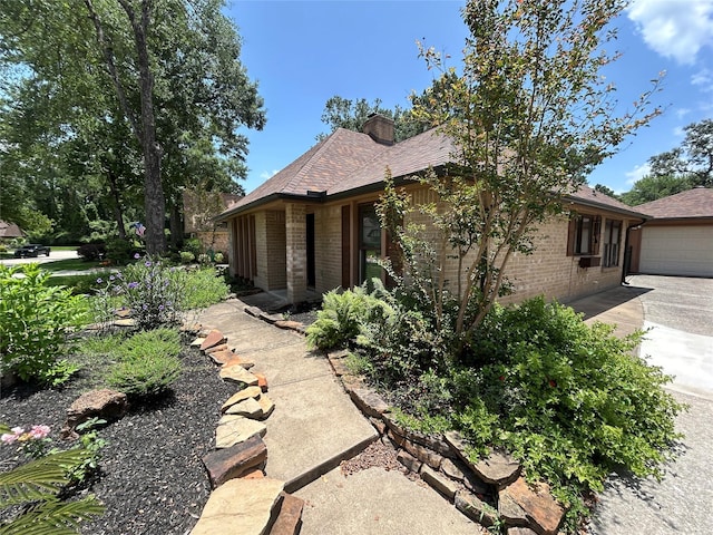 2718 Silver Falls Dr, Kingwood, TX 77339 - view of side of property with brick siding, a chimney, a garage, concrete driveway, and roof with shingles