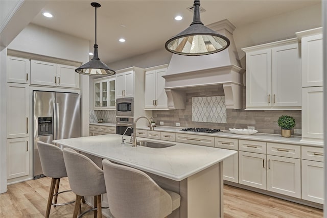 130 Playmoor Pl, Montgomery, TX 77316 - kitchen with a sink, stainless steel appliances, light wood-style flooring, decorative backsplash, and recessed lighting