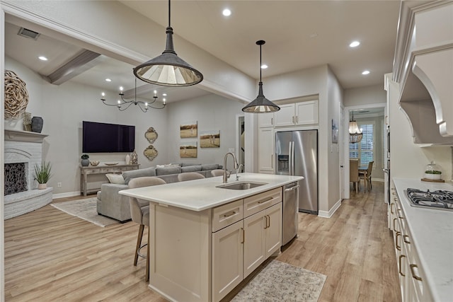 130 Playmoor Pl, Montgomery, TX 77316 - kitchen featuring a sink, appliances with stainless steel finishes, a chandelier, open floor plan, and light wood finished floors