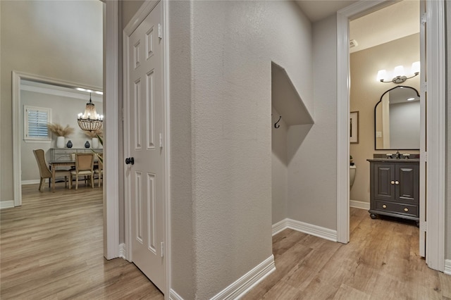 130 Playmoor Pl, Montgomery, TX 77316 - hall with light wood-type flooring, a chandelier, a sink, and baseboards