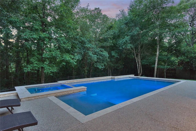 130 Playmoor Pl, Montgomery, TX 77316 - pool at dusk featuring a fenced backyard, a patio area, and a pool with connected hot tub