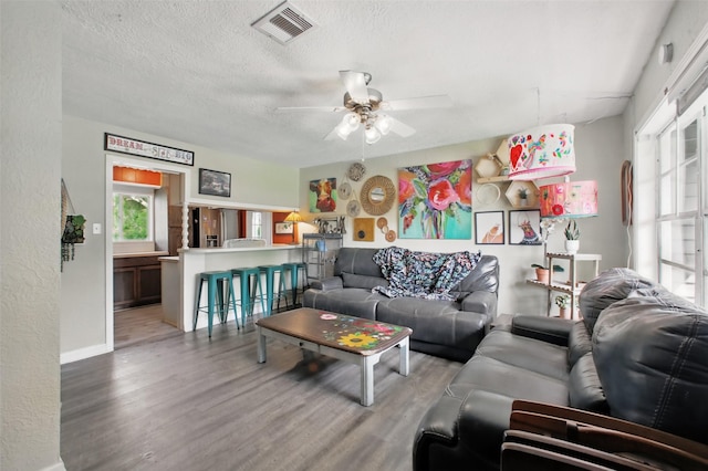 603 Briarwood Dr, Baytown, TX 77520 - living area featuring light wood finished floors, a ceiling fan, baseboards, and a textured ceiling