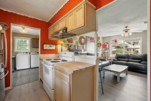 603 Briarwood Dr, Baytown, TX 77520 - kitchen with electric stove, washing machine and clothes dryer, under cabinet range hood, a textured ceiling, and wood finished floors
