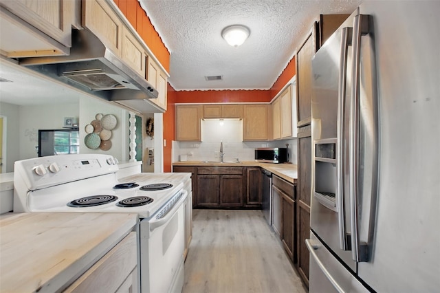 603 Briarwood Dr, Baytown, TX 77520 - kitchen with appliances with stainless steel finishes, wall chimney exhaust hood, light wood-style floors, light countertops, and a sink