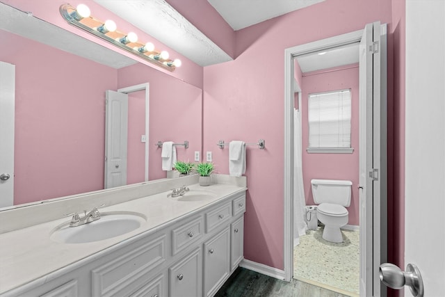 819 Maranon Ln, Houston, TX 77090 - bathroom with double vanity, wood finished floors, toilet, baseboards, and curtained shower