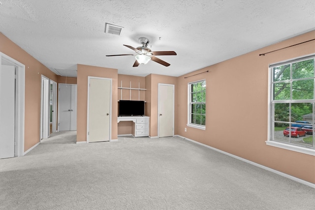 819 Maranon Ln, Houston, TX 77090 - unfurnished living room featuring attic access, a ceiling fan, light carpet, baseboards, and a textured ceiling