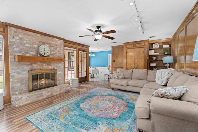 819 Maranon Ln, Houston, TX 77090 - living room featuring a ceiling fan, wood finished floors, a fireplace, and track lighting