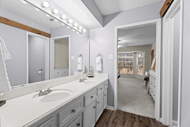 819 Maranon Ln, Houston, TX 77090 - full bathroom with double vanity, wood finished floors, ceiling fan, and baseboards