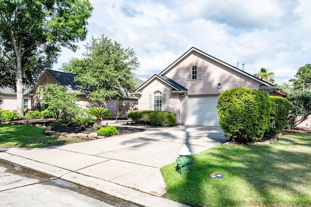 51 Eagle Mead Pl, The Woodlands, TX 77382 - view of front facade featuring brick siding, driveway, a front yard, and an attached garage