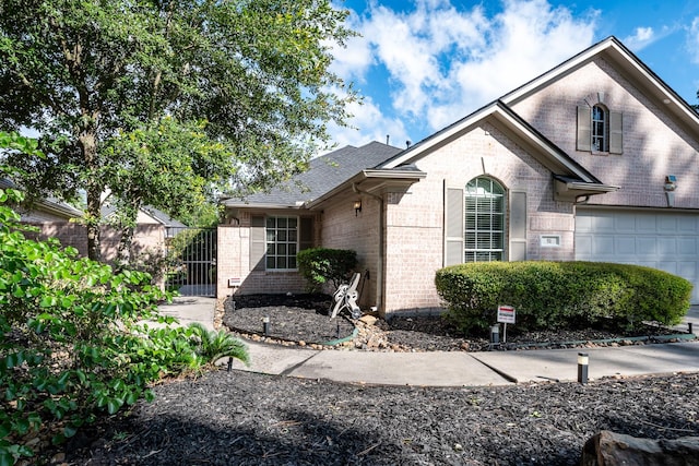 51 Eagle Mead Pl, The Woodlands, TX 77382 - view of front of home with brick siding, a gate, a garage, and a shingled roof