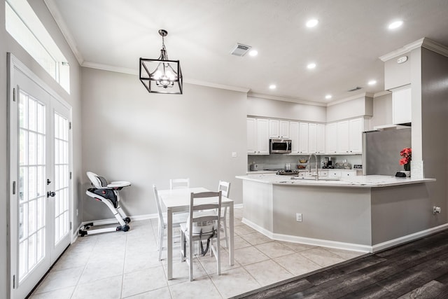 51 Eagle Mead Pl, The Woodlands, TX 77382 - kitchen with stainless steel appliances, a sink, backsplash, white cabinetry, and ornamental molding