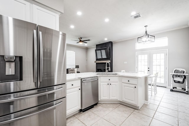 51 Eagle Mead Pl, The Woodlands, TX 77382 - kitchen with appliances with stainless steel finishes, a sink, crown molding, white cabinets, and light tile patterned floors