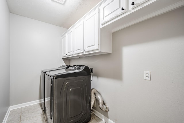 51 Eagle Mead Pl, The Woodlands, TX 77382 - laundry area with cabinet space, washing machine and clothes dryer, baseboards, and light tile patterned floors