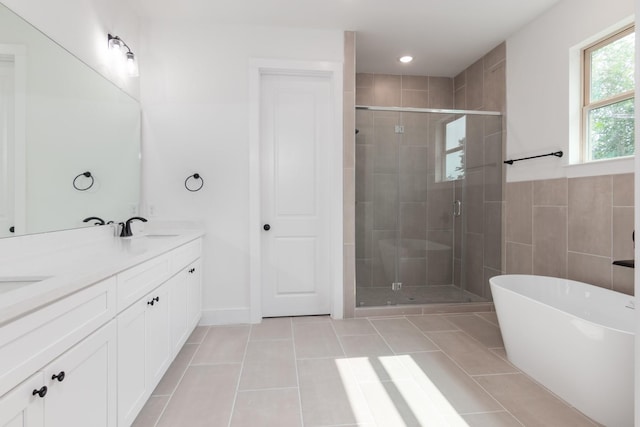 1411 E 34th St, Houston, TX 77022 - bathroom with double vanity, a stall shower, tile patterned flooring, and a soaking tub