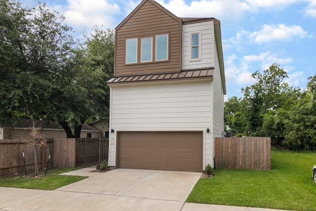 1411 E 34th St, Houston, TX 77022 - view of front facade with a standing seam roof, an attached garage, metal roof, and driveway