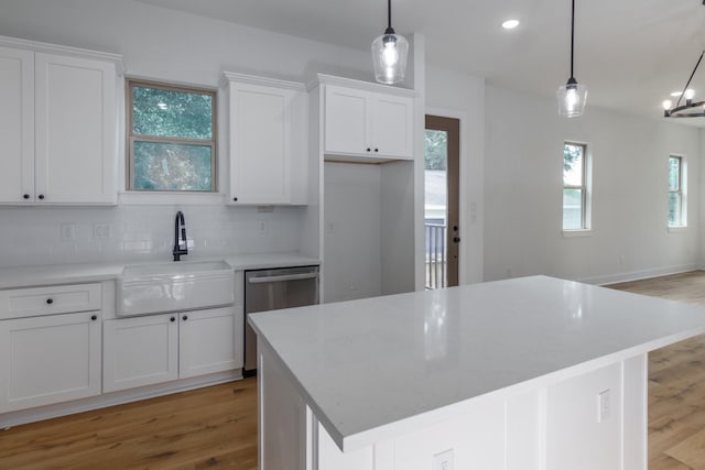1411 E 34th St, Houston, TX 77022 - kitchen with dishwasher, a sink, light wood-style flooring, tasteful backsplash, and white cabinets