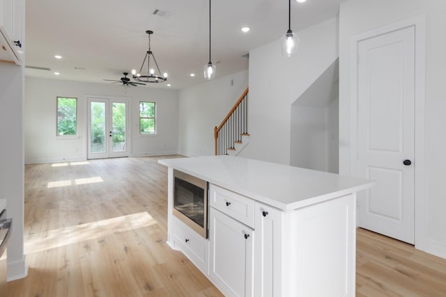 1411 E 34th St, Houston, TX 77022 - kitchen with built in microwave, light wood-type flooring, a chandelier, recessed lighting, and white cabinetry