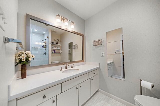 6417 Olympia Dr Unit 144, Houston, TX 77057 - bathroom with toilet, vanity, tiled shower, and baseboards