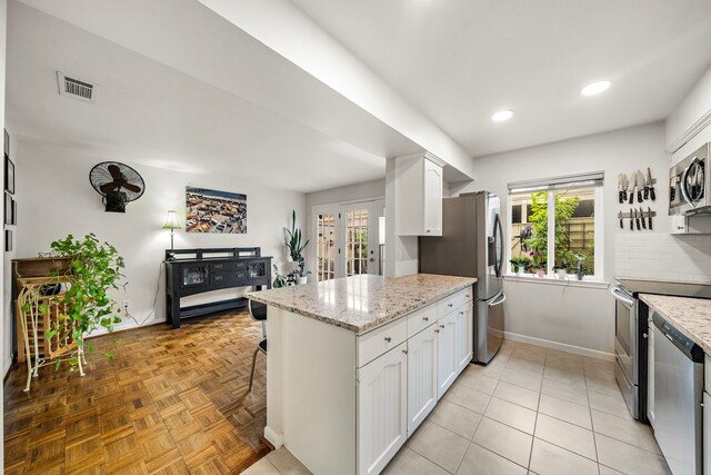 6417 Olympia Dr Unit 144, Houston, TX 77057 - kitchen with stainless steel appliances, white cabinetry, a peninsula, baseboards, and recessed lighting