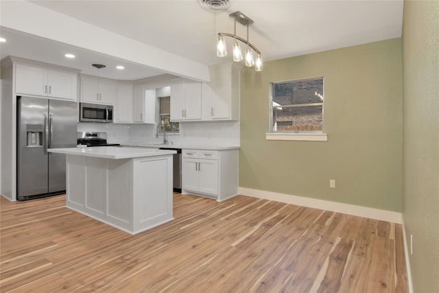 1105 W Dr, Port Neches, TX 77651 - kitchen featuring stainless steel appliances, baseboards, light countertops, white cabinets, and light wood finished floors