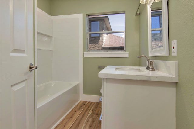 1105 W Dr, Port Neches, TX 77651 - full bathroom with wood finished floors, vanity, baseboards, toilet, and shower / tub combination