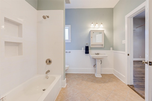 1318 Bingham St, Houston, TX 77007 - bathroom featuring toilet, bathing tub / shower combination, a wainscoted wall, and tile patterned flooring