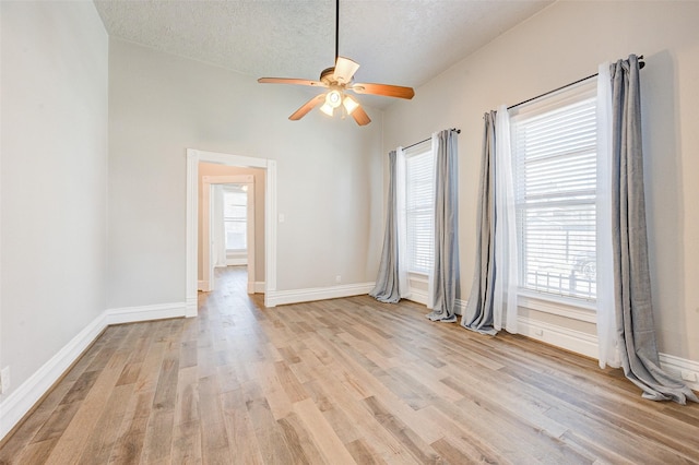 1318 Bingham St, Houston, TX 77007 - empty room with light wood-type flooring, ceiling fan, baseboards, and a textured ceiling