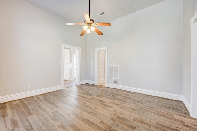 1318 Bingham St, Houston, TX 77007 - spare room featuring ceiling fan, light wood finished floors, baseboards, and a towering ceiling