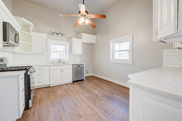 1318 Bingham St, Houston, TX 77007 - kitchen with stainless steel appliances, a sink, open shelves, decorative backsplash, and ceiling fan