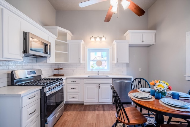 1318 Bingham St, Houston, TX 77007 - kitchen with stainless steel appliances, a sink, light wood-type flooring, light countertops, and white cabinets